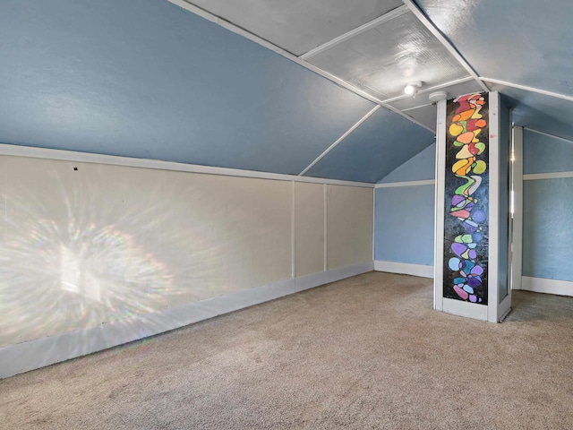 bonus room with carpet flooring and vaulted ceiling