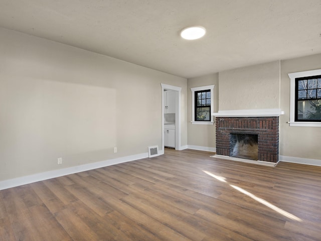 unfurnished living room with wood-type flooring and a fireplace