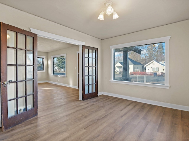 unfurnished room with hardwood / wood-style floors and french doors