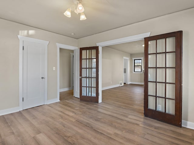 unfurnished room with hardwood / wood-style flooring and french doors