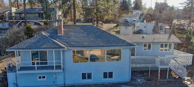 rear view of house featuring a chimney and a deck