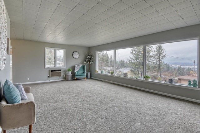 unfurnished room with carpet, a wall mounted air conditioner, and baseboards