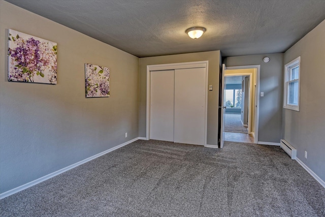 unfurnished bedroom with a textured ceiling, carpet flooring, baseboards, a closet, and baseboard heating