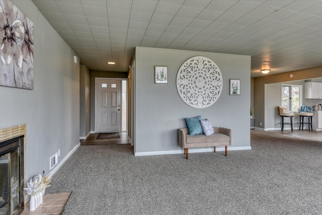 interior space with carpet, a fireplace with flush hearth, visible vents, and baseboards