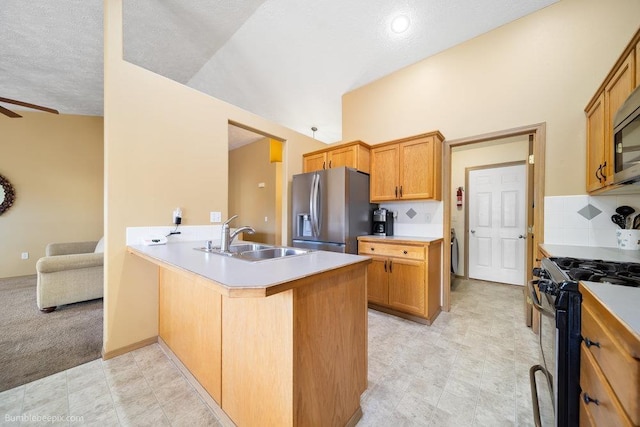 kitchen featuring sink, tasteful backsplash, kitchen peninsula, ceiling fan, and stainless steel appliances