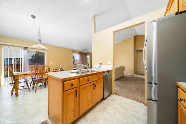 kitchen featuring appliances with stainless steel finishes, sink, hanging light fixtures, kitchen peninsula, and plenty of natural light