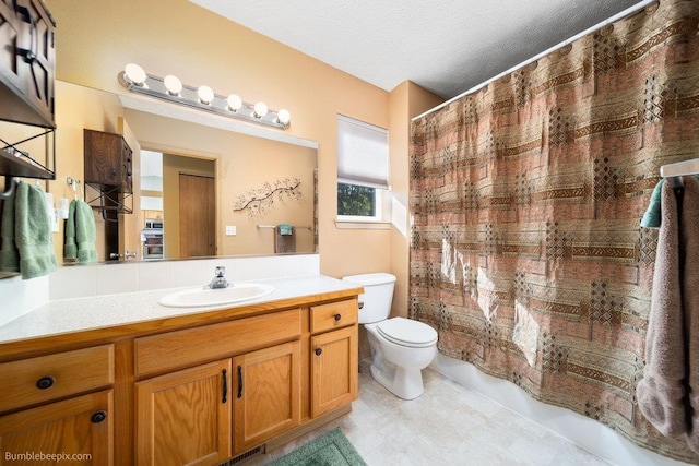 bathroom with vanity, toilet, and a textured ceiling