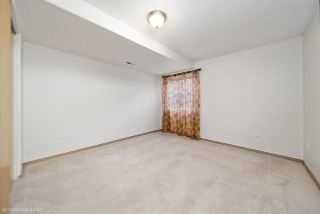 carpeted empty room with a textured ceiling