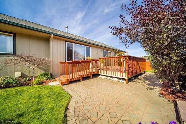 exterior space with a patio area, a lawn, and a deck