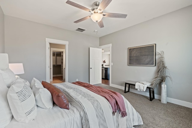 carpeted bedroom featuring a spacious closet, ceiling fan, and a closet