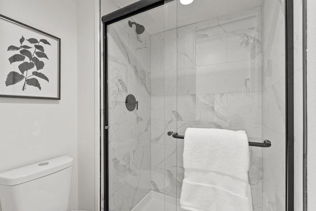 bathroom with toilet and a shower with shower door