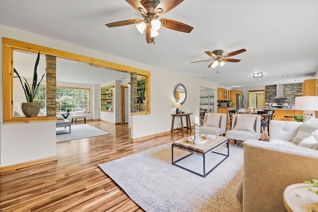 living room featuring ceiling fan and light hardwood / wood-style floors