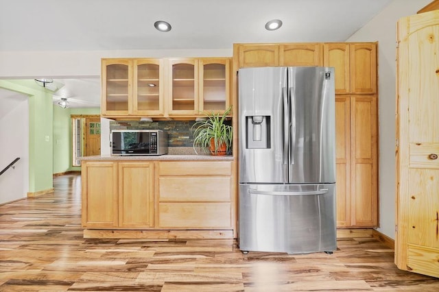 kitchen with light brown cabinetry, light hardwood / wood-style flooring, and appliances with stainless steel finishes