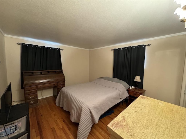 bedroom with hardwood / wood-style flooring, crown molding, and a textured ceiling