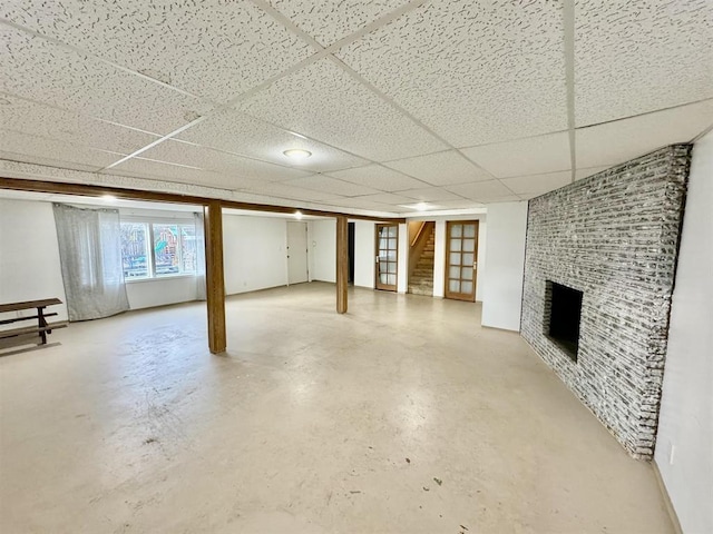 basement with a fireplace and a paneled ceiling