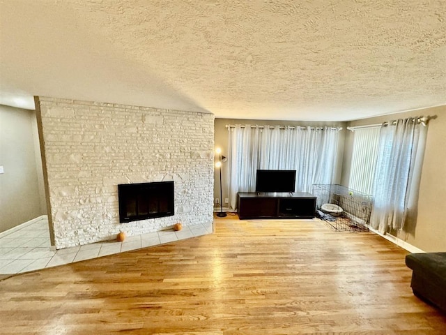 unfurnished living room with a fireplace, hardwood / wood-style floors, and a textured ceiling