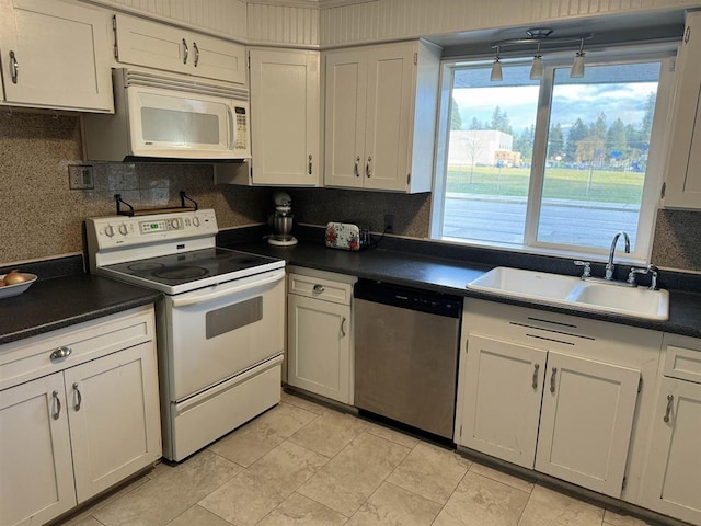 kitchen featuring white cabinetry, sink, and white appliances