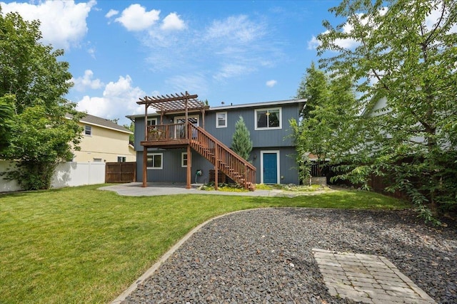 back of property featuring a wooden deck, a pergola, a patio area, and a lawn