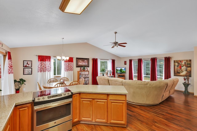 kitchen featuring lofted ceiling, decorative light fixtures, wood-type flooring, and electric range