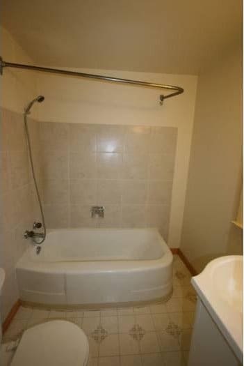 full bathroom with vanity, toilet, and tiled shower / bath combo