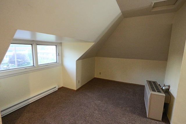 additional living space featuring a baseboard heating unit, vaulted ceiling, radiator, and dark colored carpet