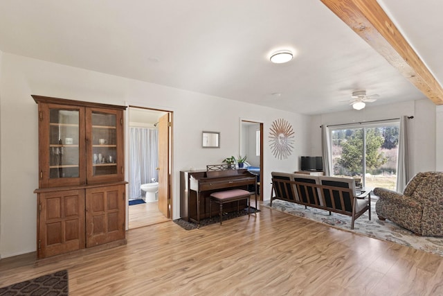 living room featuring beam ceiling, ceiling fan, and light hardwood / wood-style floors