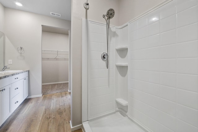 bathroom featuring hardwood / wood-style flooring, vanity, and walk in shower