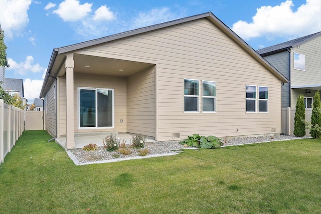 rear view of house featuring a lawn and a patio area