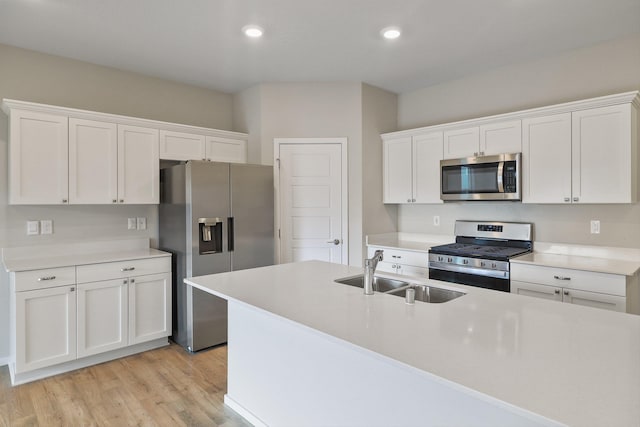 kitchen featuring white cabinetry, sink, stainless steel appliances, and light hardwood / wood-style flooring