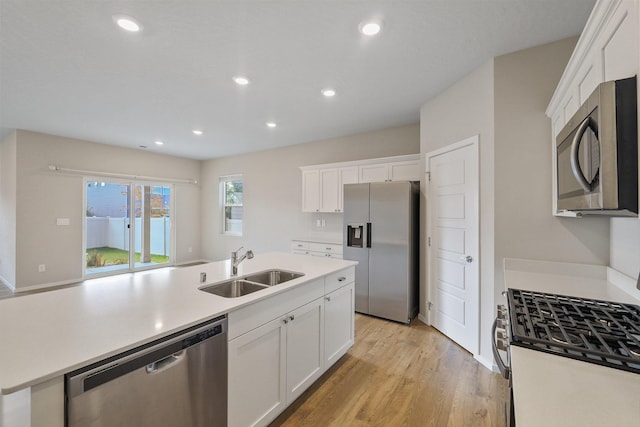 kitchen featuring light hardwood / wood-style flooring, sink, stainless steel appliances, and white cabinetry