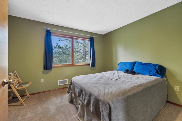 bedroom with light colored carpet and a textured ceiling