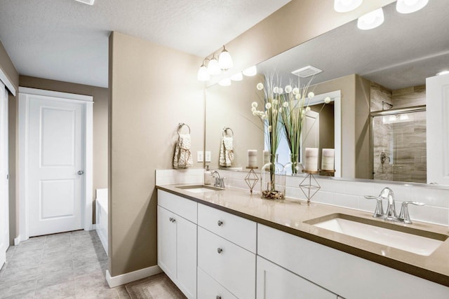 bathroom featuring vanity, independent shower and bath, and a textured ceiling