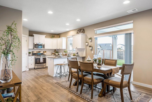 dining room featuring sink, plenty of natural light, and light wood-type flooring