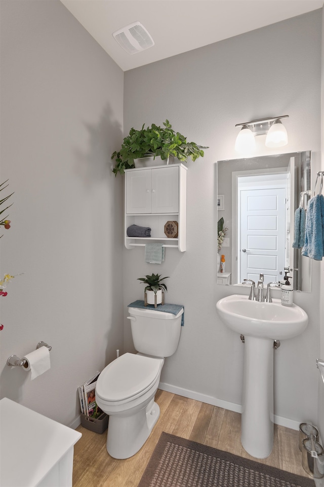 bathroom featuring wood-type flooring, sink, and toilet