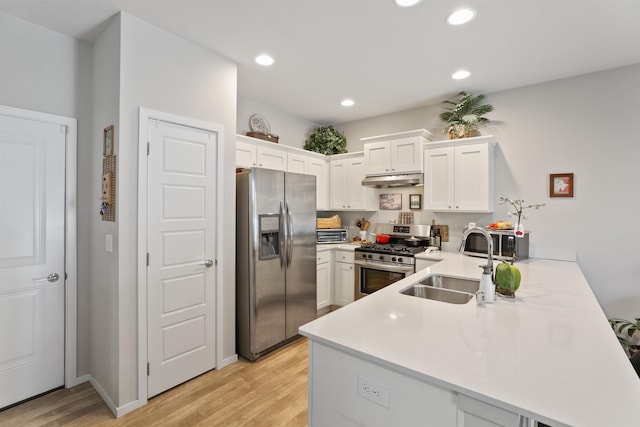 kitchen featuring stainless steel appliances, sink, white cabinets, and kitchen peninsula