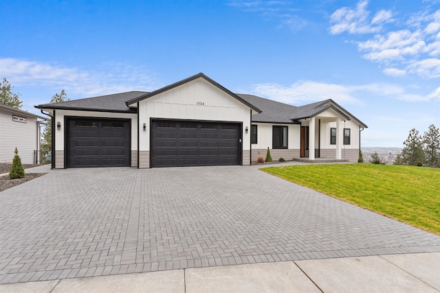 modern inspired farmhouse with a garage and a front lawn