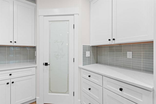 kitchen with tasteful backsplash and white cabinetry