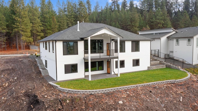 rear view of house with a yard and a patio