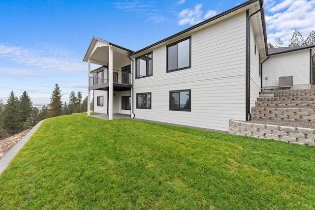 rear view of property featuring a balcony, a yard, and a patio area