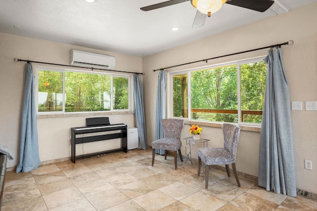 sitting room featuring ceiling fan and a wall mounted AC