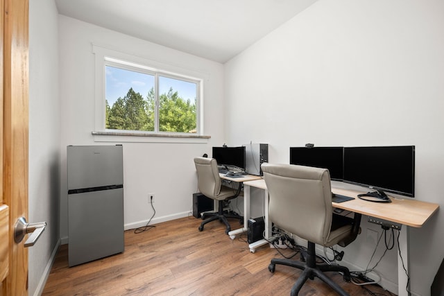 office space with vaulted ceiling and light wood-type flooring