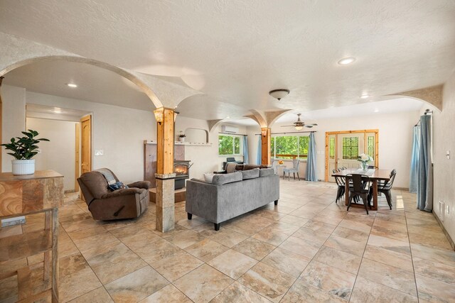 living room with ceiling fan and a textured ceiling