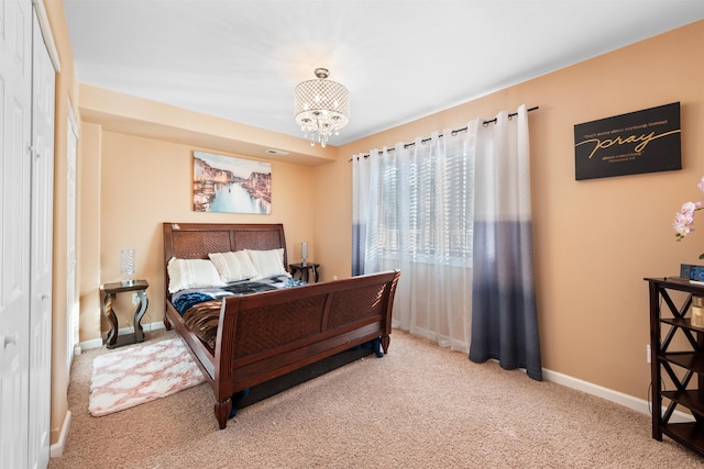 bedroom featuring an inviting chandelier and carpet floors