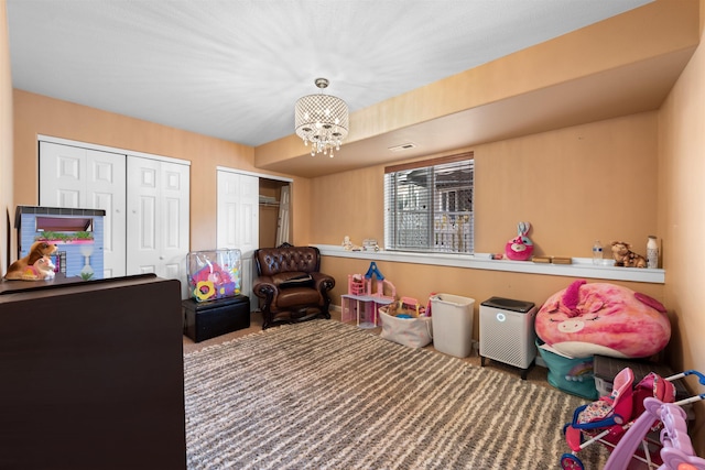 recreation room featuring an inviting chandelier and carpet floors