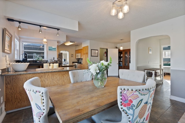 dining room featuring a textured ceiling and dark tile patterned floors