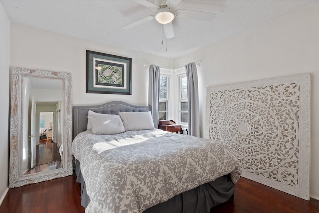 bedroom with ceiling fan, dark hardwood / wood-style floors, and a textured ceiling