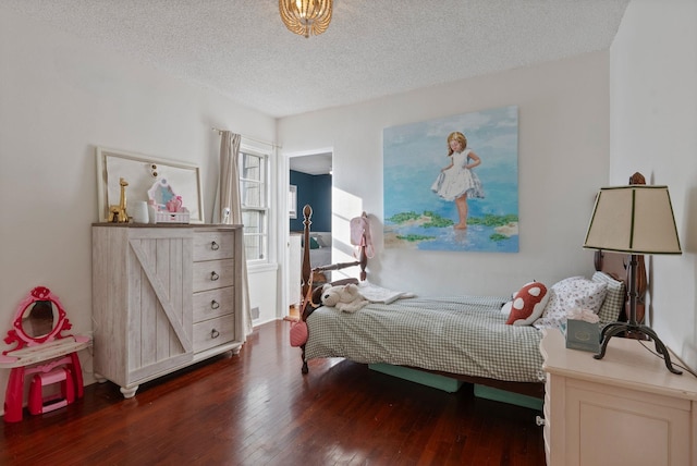 bedroom with a textured ceiling and dark hardwood / wood-style flooring