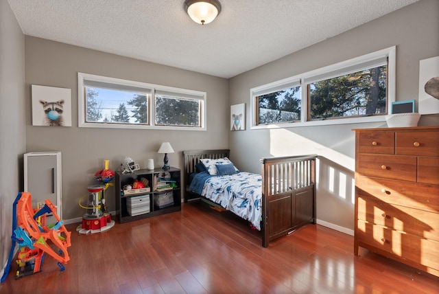 bedroom with hardwood / wood-style floors and a textured ceiling