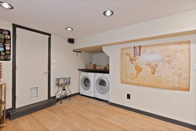 laundry room with hardwood / wood-style flooring, separate washer and dryer, and a textured ceiling