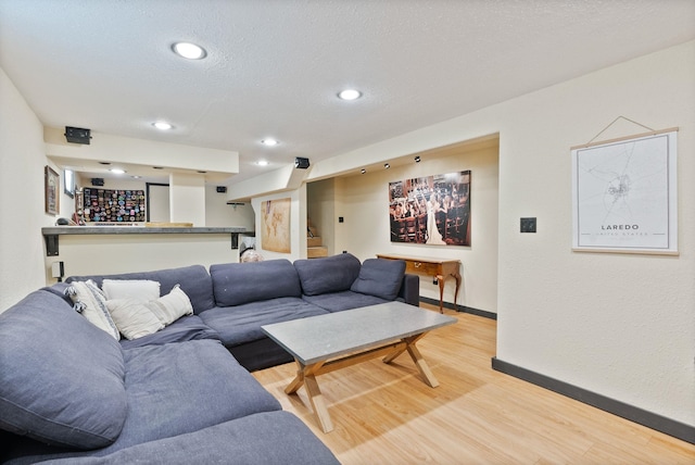 living room with light hardwood / wood-style floors and a textured ceiling